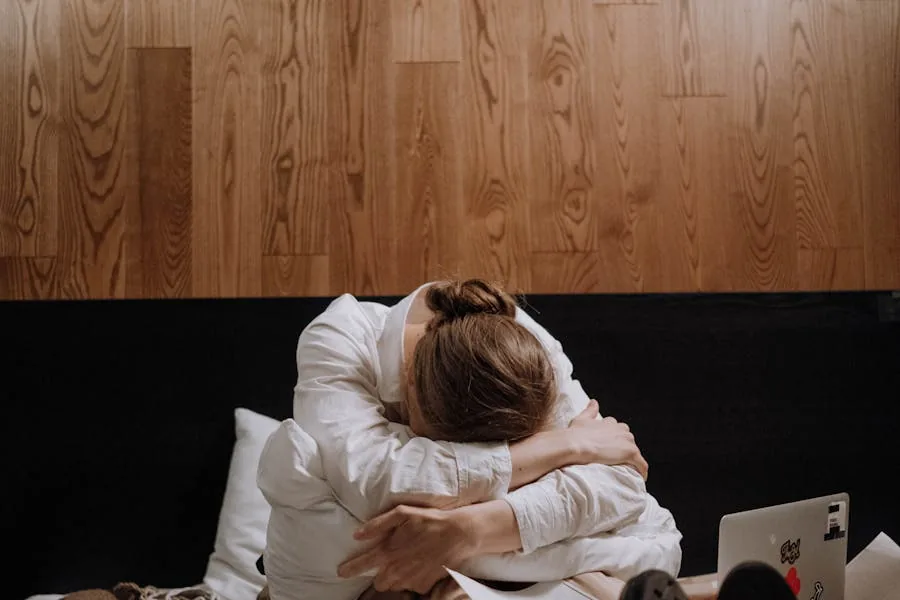 Tired woman sitting on the edge of her bed in the morning