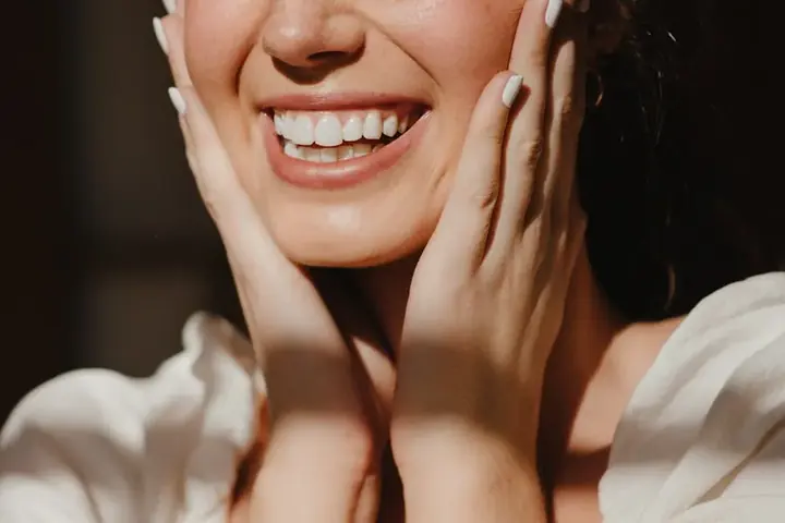 Natural close-up portrait of a woman with a bright, confident smile